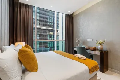 a bedroom with a bed and a desk and a window at Luxury 2 Bedroom Apartment DAMAC Uppercrest Downtown Near Dubai Mall in Dubai