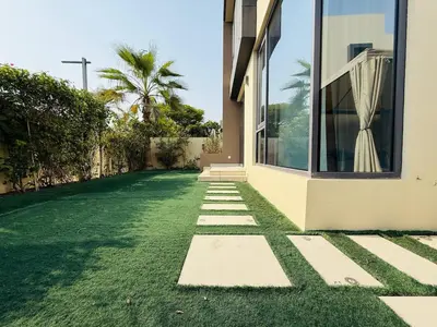 a house with a grass yard next to a building at 5 bedroom Villa in Maple 2 Dubai Hills Estate in Dubai