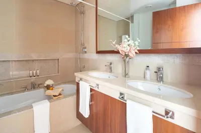 a bathroom with two sinks and a tub with towels at Frank Porter - Burj Vista Tower 1 in Dubai