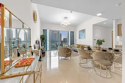a dining room and living room with a table and chairs at Glamarous 2BR Burj Khalifa & Fountain Views in Dubai