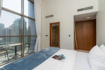 a bedroom with a bed and a large window at Scenic - Contemporary - Marina Getaway in Dubai
