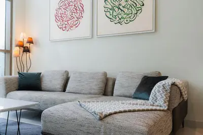a living room with a couch and two pictures on the wall at Scenic - Contemporary - Marina Getaway in Dubai