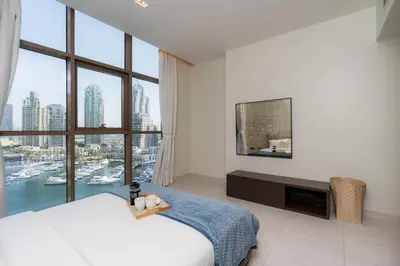 a bedroom with a large bed and a large window at Scenic - Contemporary - Marina Getaway in Dubai