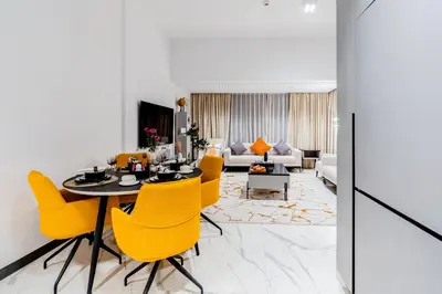 a dining room with a table and yellow chairs at Luxurious 1BR Retreat in MAG City Dubai in Dubai
