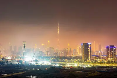 a city skyline at night with lights at Luxurious 1BR Retreat in MAG City Dubai in Dubai