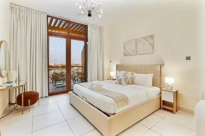 a white bedroom with a large bed and a window at Elegant Studio on Palm Jumeirah With Stunning Views in Dubai