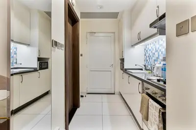 a kitchen with white cabinets and a white door at Elegant Studio on Palm Jumeirah With Stunning Views in Dubai