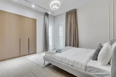 a white bedroom with a bed and a large window at Luxury 1BR in Sulafa Tower by EE Holiday Homes in Dubai