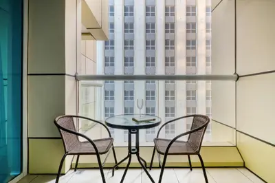a table and two chairs in a room with a window at Luxury 1BR in Sulafa Tower by EE Holiday Homes in Dubai
