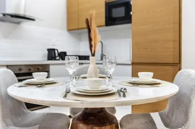 a dining room table with chairs and a white table centerpiece at Luxury 1BR in Sulafa Tower by EE Holiday Homes in Dubai