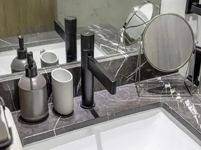 a sink with bottles and a mirror on a counter at Livin' Holidays - Studio - Stylish flat in JVC in Dubai