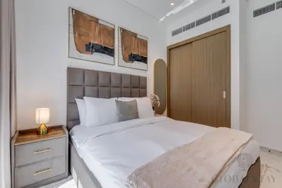 a bedroom with a large white bed and a nightstand at GlobalStay Azizi Riviera 67 Apartments Dubai in Dubai