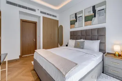 a bedroom with a large bed and a desk at GlobalStay Azizi Riviera 67 Apartments Dubai in Dubai