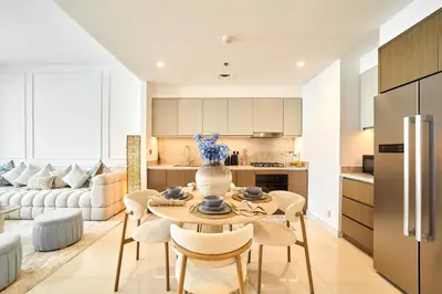 a kitchen and living room with a table and chairs at Luxury 2BR Beach Isle With Palm Views and Beach Access in Dubai