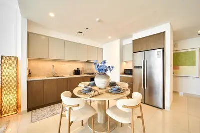 a kitchen with a table and chairs and a refrigerator at Luxury 2BR Beach Isle With Palm Views and Beach Access in Dubai