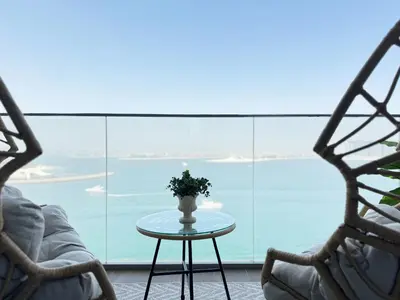 a table with a vase on it in front of a window at Luxury 2BR Beach Isle With Palm Views and Beach Access in Dubai