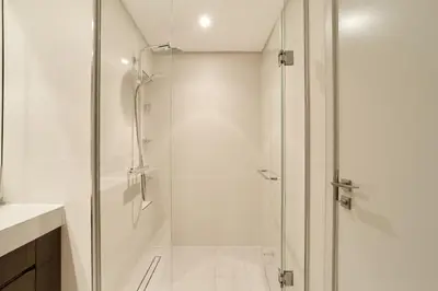 a shower with a glass door in a bathroom at Luxury 2BR Beach Isle With Palm Views and Beach Access in Dubai
