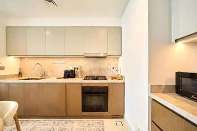 a kitchen with white cabinets and a stove top oven at Luxury 2BR Beach Isle With Palm Views and Beach Access in Dubai