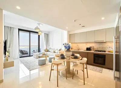 a kitchen and living room with a table and chairs at Luxury 2BR Beach Isle With Palm Views and Beach Access in Dubai