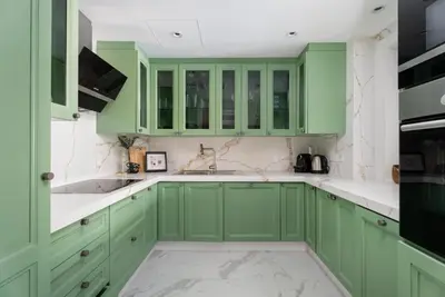 a kitchen with green cabinets and marble counters at GuestReady - 2BR | Downtown Bliss with Burj View in Dubai