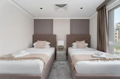 two beds in a room with a window at GuestReady - 2BR | Downtown Bliss with Burj View in Dubai