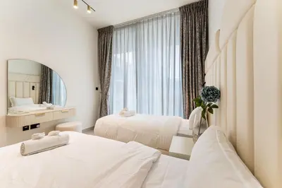 a hotel room with two beds and a mirror at HAVN - New 2 Bedroom in Binghatti Amber, JVC in Dubai