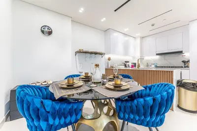 a dining room with blue chairs and a table at HAVN - New 2 Bedroom in Binghatti Amber, JVC in Dubai