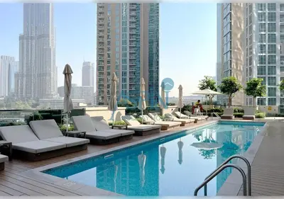 a swimming pool with lounge chairs and a building at Aspin 3BR Iconic Burj Khalifa Live Fountain View in Dubai