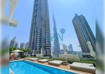 a pool in front of some tall buildings at Aspin 3BR Iconic Burj Khalifa Live Fountain View in Dubai