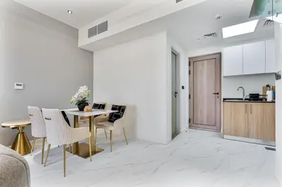 a kitchen and dining room with a table and chairs at Stylish 1BR Villa near Global Village and Golf Clubs in Dubai