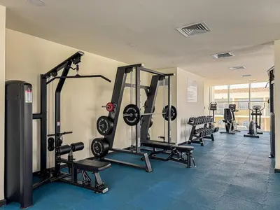 a gym with several treadmills and machines in a room at Stylish 1BR Villa near Global Village and Golf Clubs in Dubai