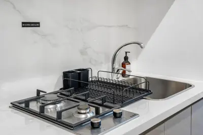 a kitchen sink with a drying rack over the stove at Livin' Holidays - Studio - Stylish Stay in Azizi in Dubai