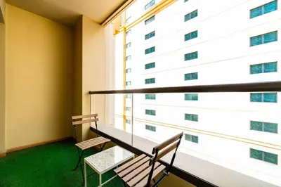 a balcony with two benches and a large window at SettlerHomes - Stunning JBR 2BR Just 5mins To The Beach in Dubai