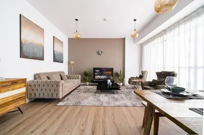 a living room with a couch and a tv at SettlerHomes - Stunning JBR 2BR Just 5mins To The Beach in Dubai