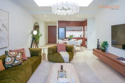 a living room with two couches and a dining room at Private Beach and Pool Vibes at Palace Residences in Dubai