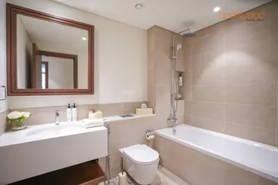 a bathroom with a tub and a toilet and a sink at Private Beach and Pool Vibes at Palace Residences in Dubai