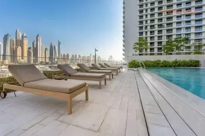 a row of chaise lounges on the roof of a building at Private Beach and Pool Vibes at Palace Residences in Dubai