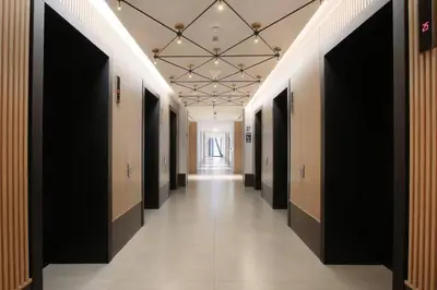 a hallway with a row of black doors and a hallwayngthngthngth at Marquise Square 410 in Dubai
