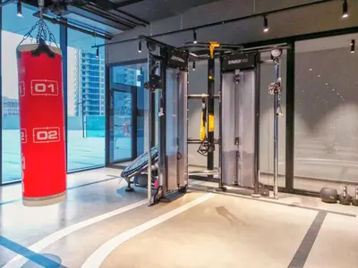 a gym with two exercise machines and a large window at Marquise Square 410 in Dubai