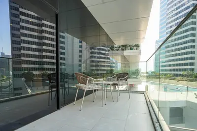 a patio with a table and chairs on a balcony at Marquise Square 410 in Dubai