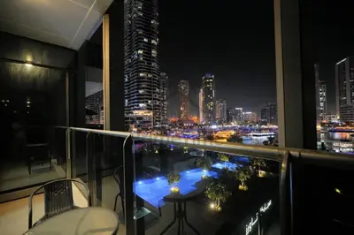 a balcony with a view of a city at night at Sparkle 205 in Dubai