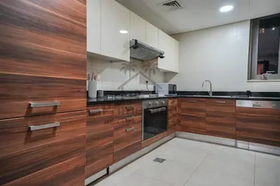 a kitchen with wooden cabinets and a sink at Sparkle 205 in Dubai