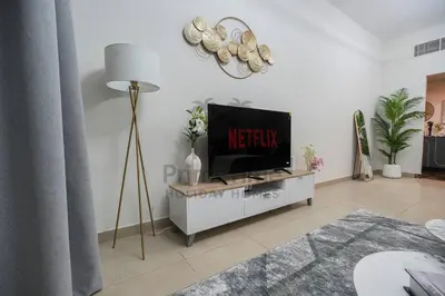 a living room with a television on a table at Sparkle 205 in Dubai