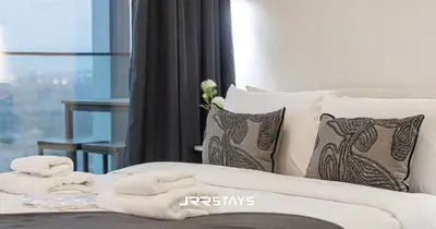 a bed with white towels on top of it at Stylish Luxury 1BR - Modern Design - JVC in Dubai