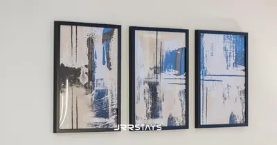 a group of four pictures hanging on a wall at Stylish Luxury 1BR - Modern Design - JVC in Dubai