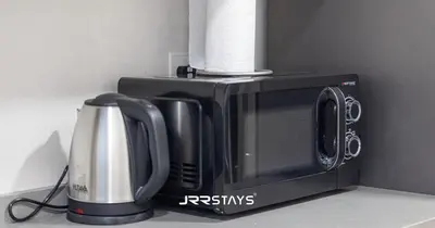 a microwave with a roll of paper towels on top of it at Stylish Luxury 1BR - Modern Design - JVC in Dubai