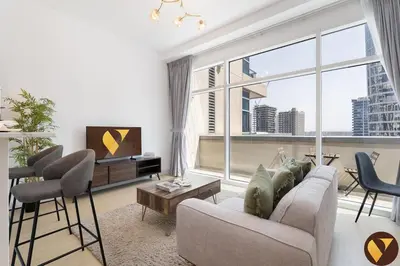 a living room with a couch and chairs and a large window at Vogue Business Bay - Bay Square close to Downtown Dubai Mall and Burj Khalifa, One Bedroom Apartment with Balcony and City view in Dubai