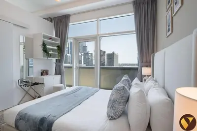 a bedroom with a large bed with a large window at Vogue Business Bay - Bay Square close to Downtown Dubai Mall and Burj Khalifa, One Bedroom Apartment with Balcony and City view in Dubai