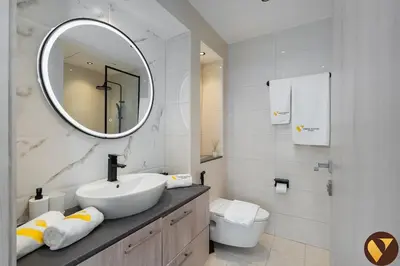 a white bathroom with a sink and a mirror at Vogue Business Bay - Bay Square close to Downtown Dubai Mall and Burj Khalifa, One Bedroom Apartment with Balcony and City view in Dubai
