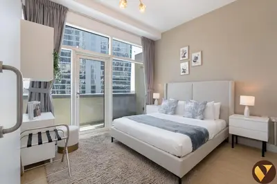 a bedroom with a bed and a large window at Vogue Business Bay - Bay Square close to Downtown Dubai Mall and Burj Khalifa, One Bedroom Apartment with Balcony and City view in Dubai